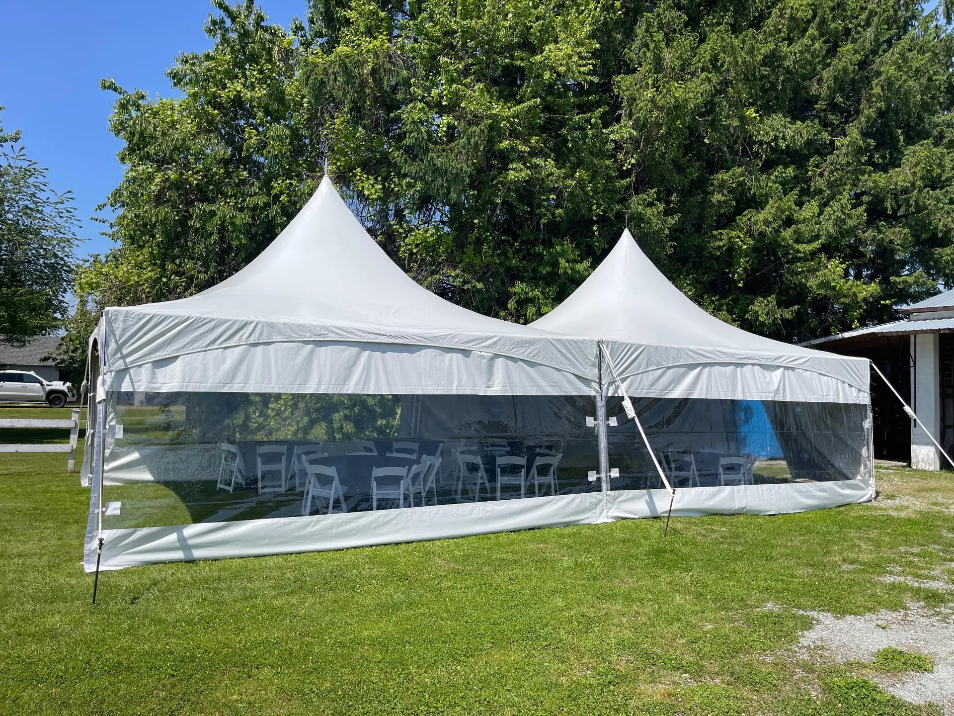 Two connected high-peak tents enclosed with clear café walls