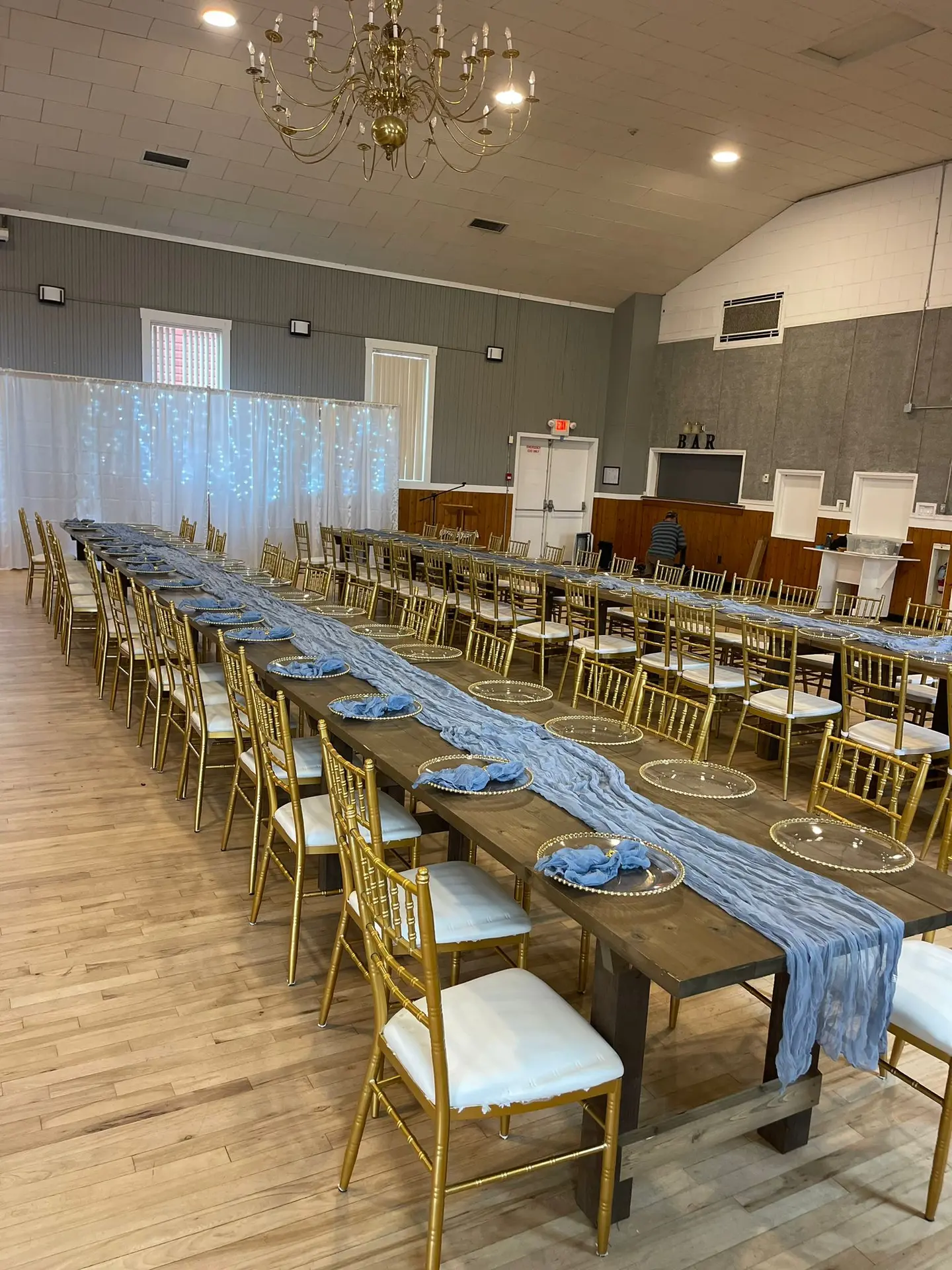 Long reception tables with gold chiavari chairs and blue table runners